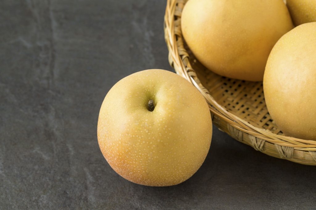 54108158 - asian pears with a bamboo basket on the slate background