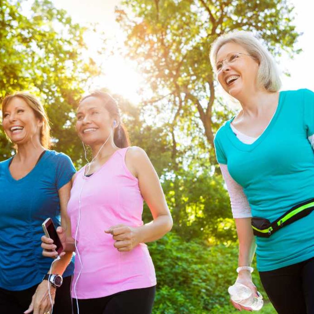 three women in workout attire exercising by walking