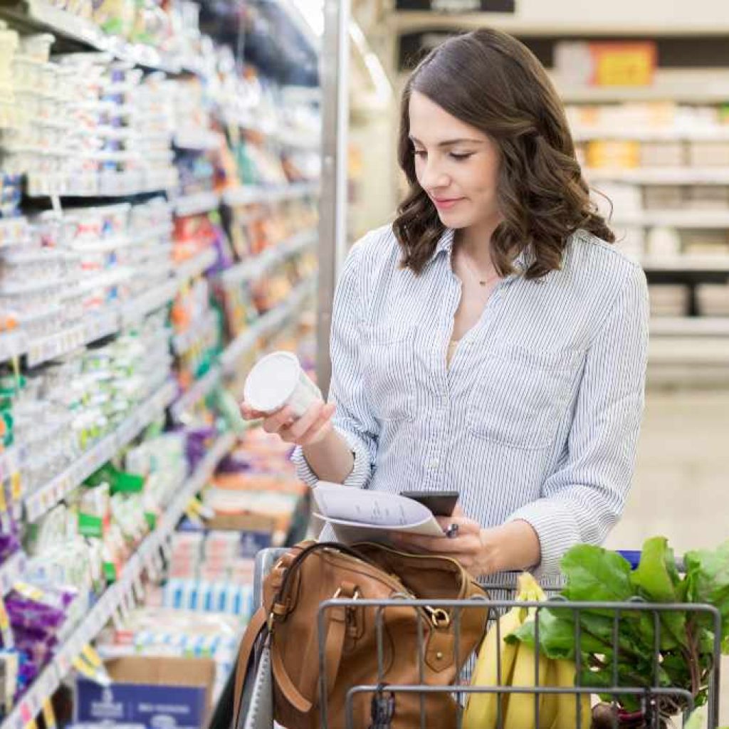 Woman in grocery store looking at the back of a product