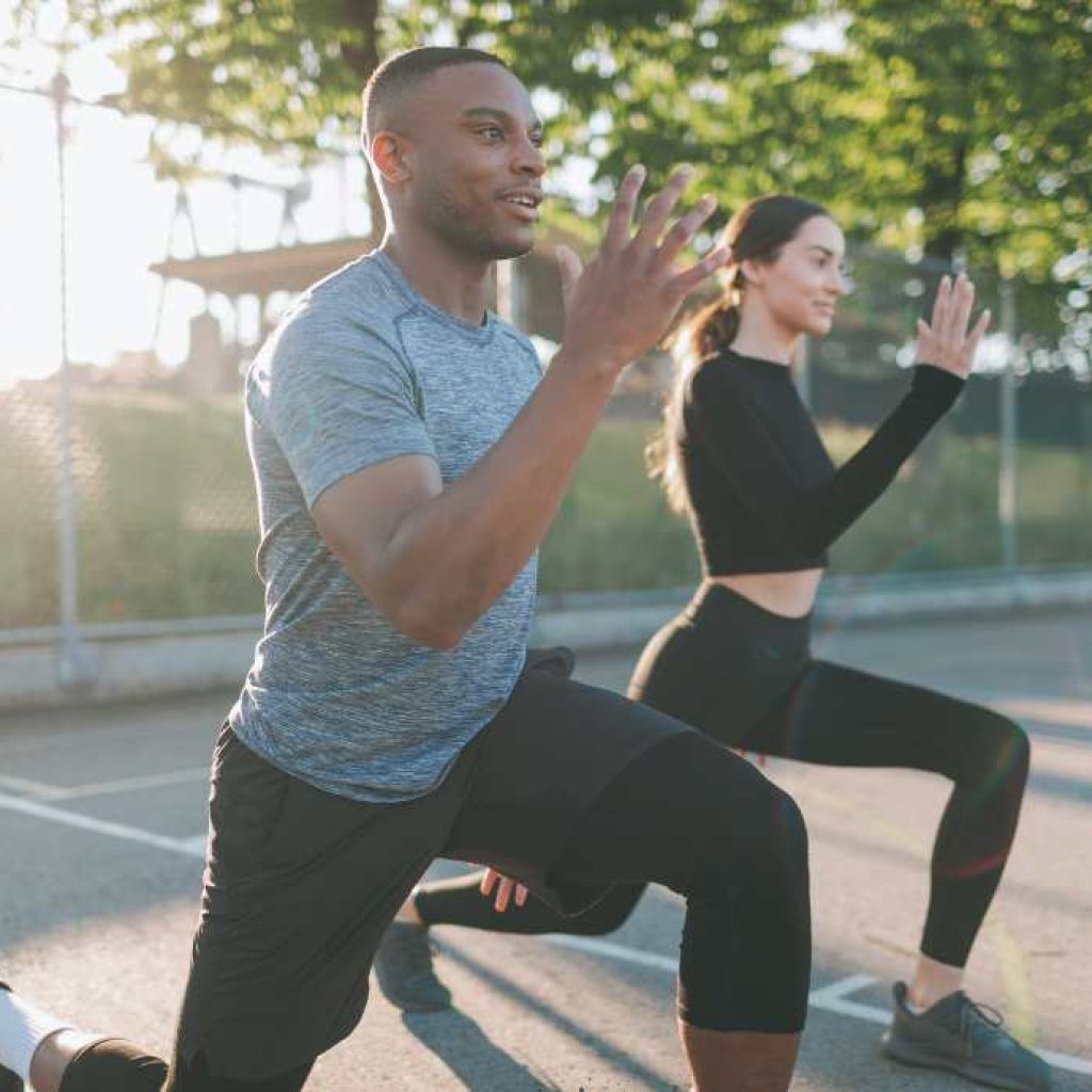 Man and woman lunging together for exercise