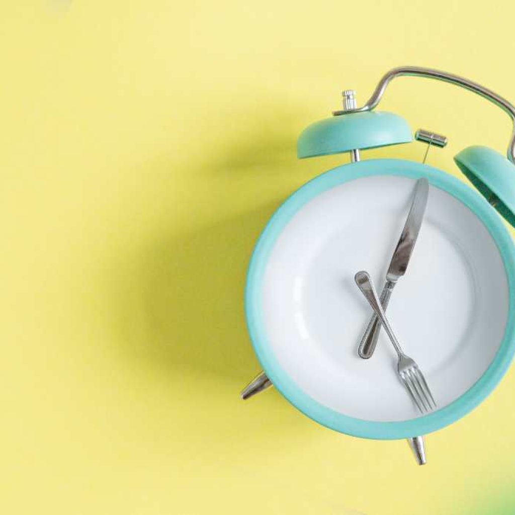 Alarm clock with fork and knife depicting the hands of the clock