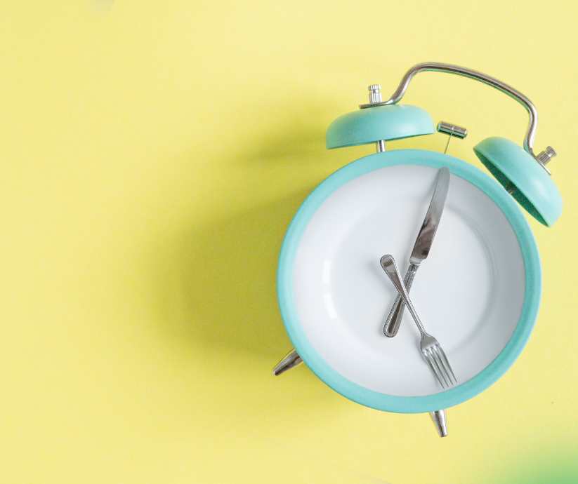 Alarm clock with fork and knife depicting the hands of the clock