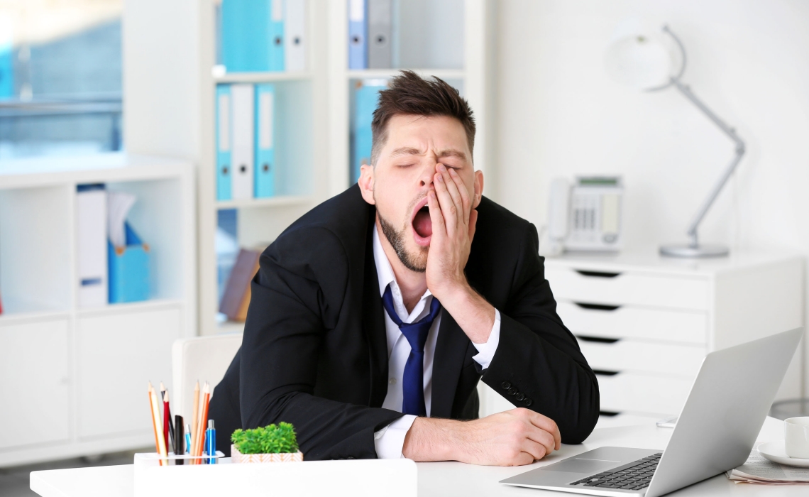 Человек зевает в офисе
