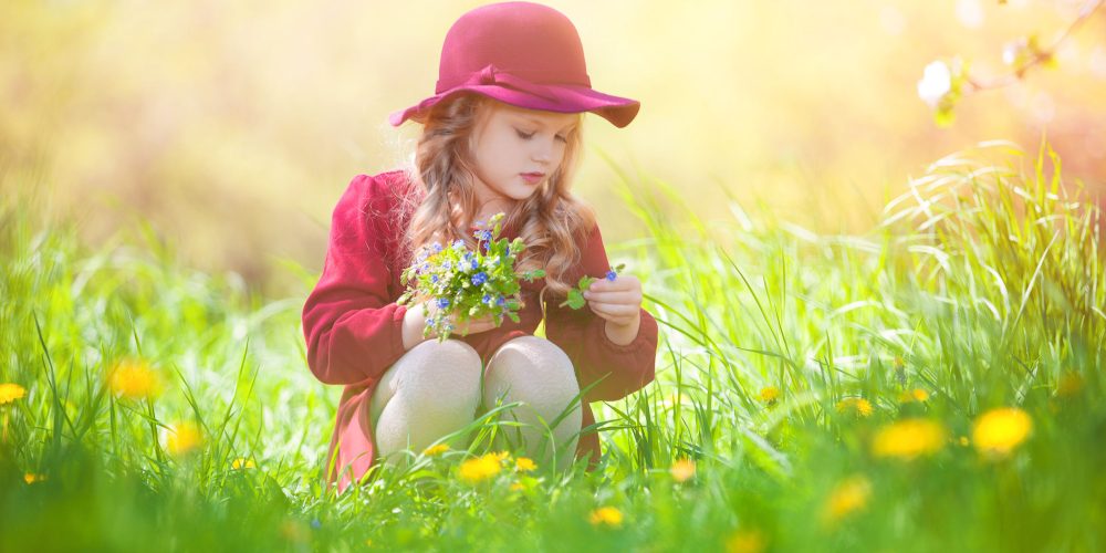 58120720 - beautiful little girl picking flowers in a meadow. summer sunny day, lots of greenery and flowers.blonde girl in burgundy dress.